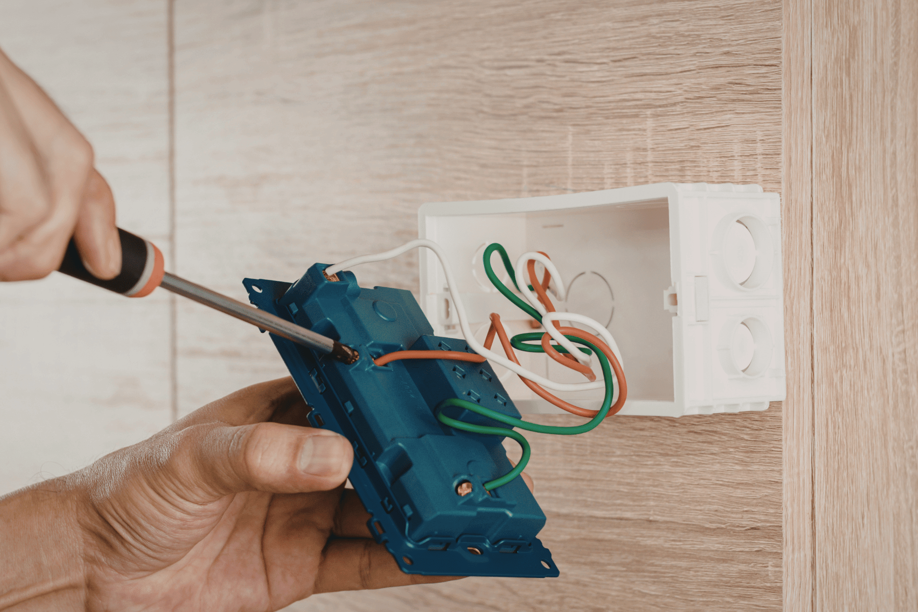 Handyman repairing a wall power outlet